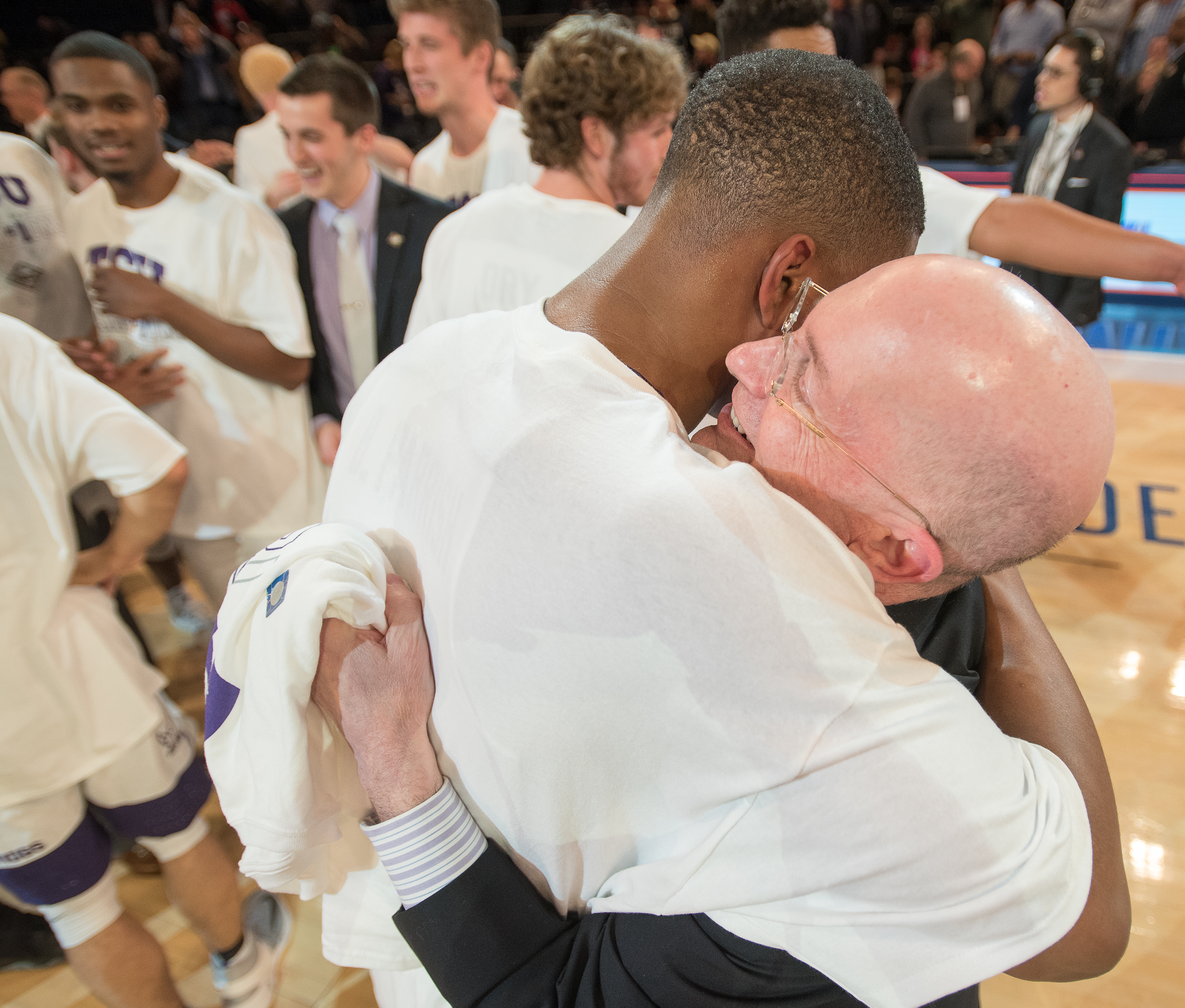 Post-game, TCU Chancellor Victor J. Boschini, Jr. hugs a TCU basketball player in celebration of the team's NIT victory.