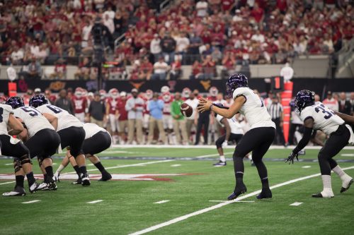 Quarterback Kenny Hill catches a snap before handing the ball off to Sewo Olonilua in the Big 12 Championship at AT&T Stadium. Photo by Leo Wesson