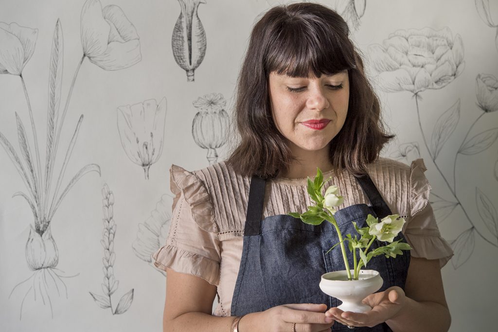 Alicia Price Rico ’04 starts a flower arrangement. She often uses ceramic vessels made in-house.