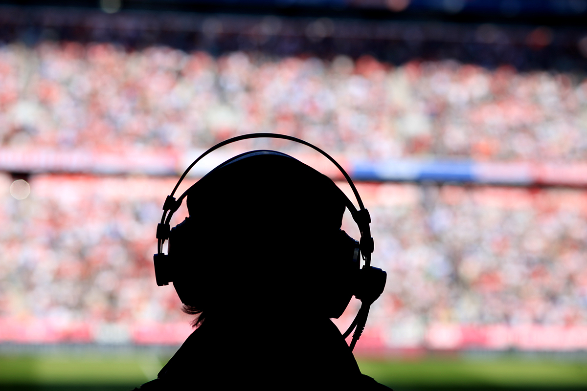 Media person with headphones at soccer stadium. Getty Images © ROLFO