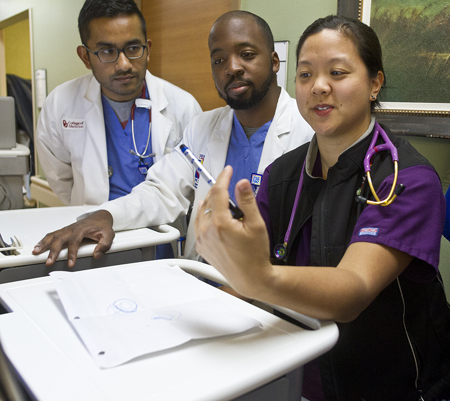 Dr. Jocelyn Zee, right, goes over a procedure with medical students Rubin Varghese (left) and Theron Bauman at John Peter Smith Hospital in Fort Worth. Photo by Mark Graham
