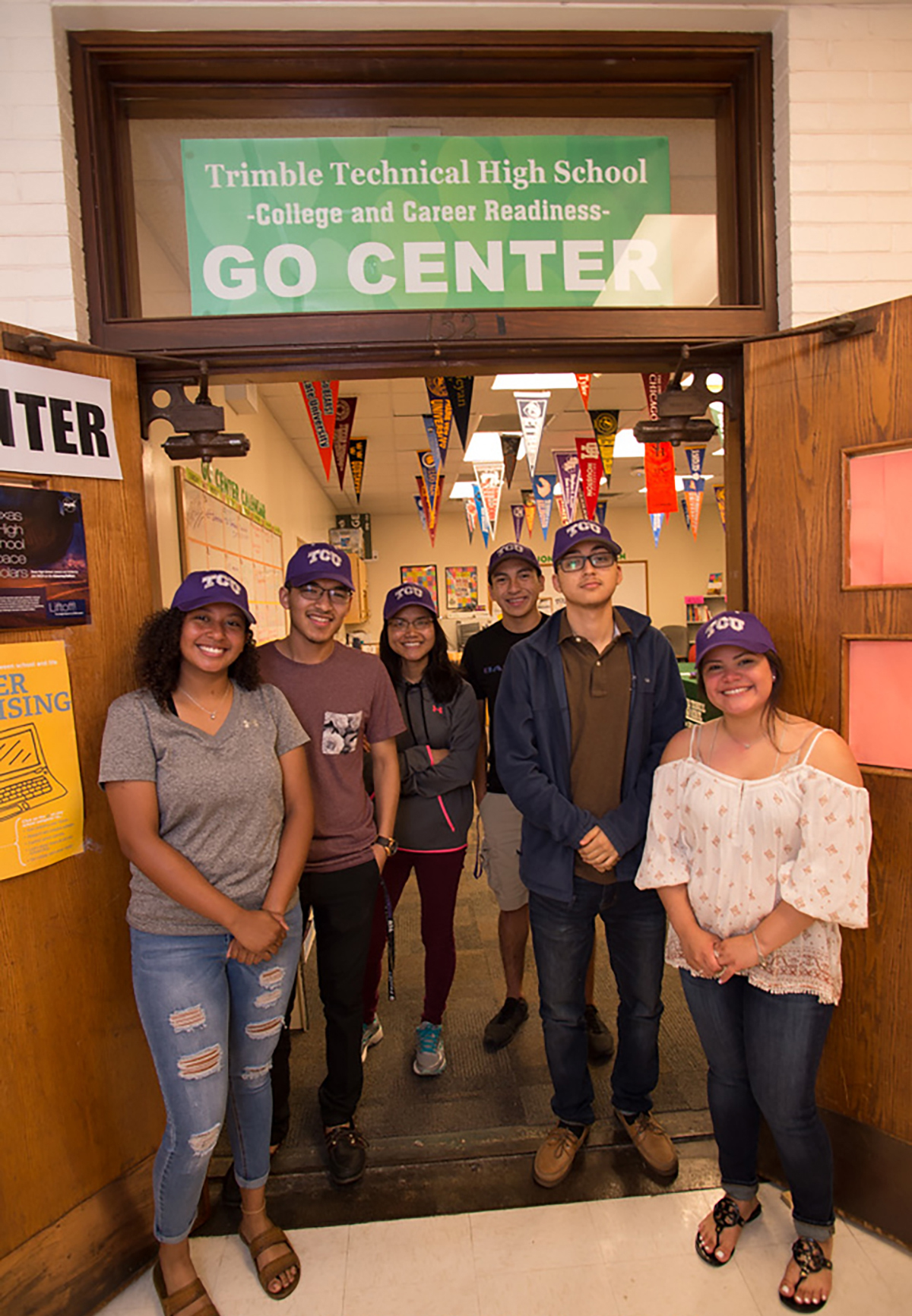 Six high school students pose wearing their TCU hats after accepting the Community Scholars scholarship. Photo by Leo Wesson