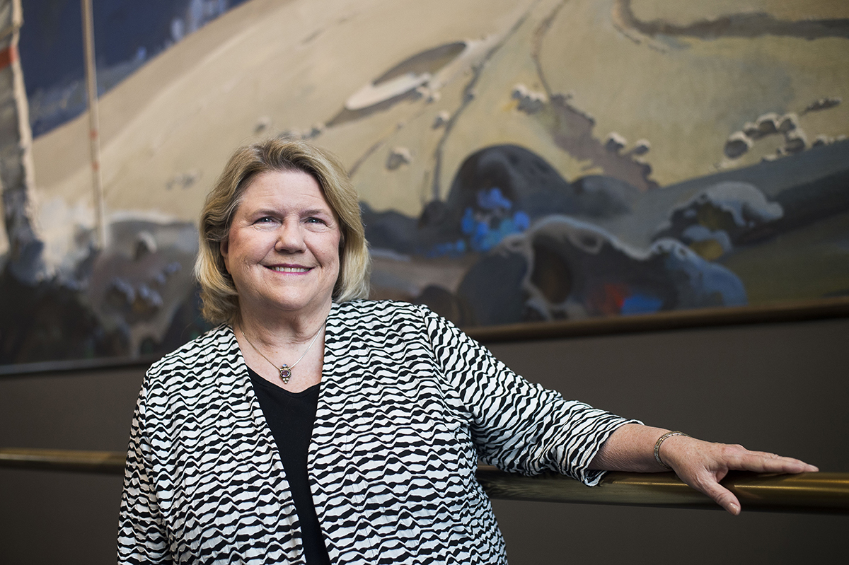 At the Smithsonian National Air and Space Museum, curator and chair of the Space History Department Valerie Neal '71 stands next to A Cosmic View, artist Robert McCall's 1976 mural celebrating space exploration. Photo by Lisa Helfert