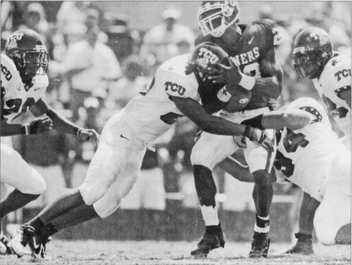 TCU sophomore safety David Roach (left) and senior defensive end Chris Hayes (right) bring down Oklahoma sophomore running back Adrian Peterson during the fourth quarter of the Horned Frogs' 17-10 victory over the Sooners in 2005. Photo courtesy of TCU Archives