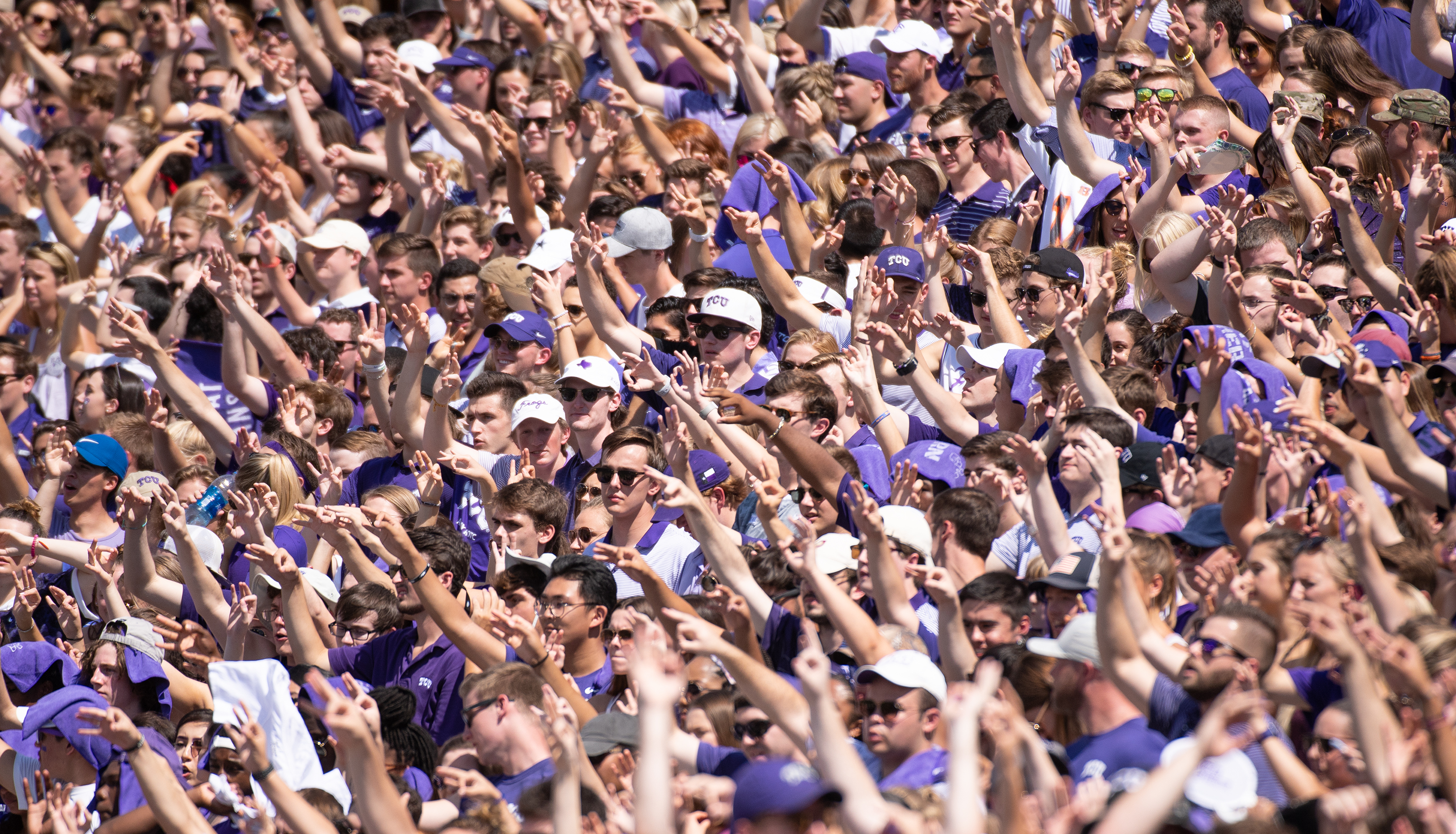 Hundreds of TCU students, in the stands at TCU's season opener against Southern, hold up three fingers to indicate a third down. Photo by Glen E. Ellman