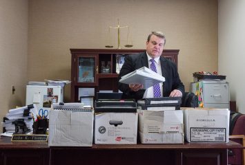 In his office in Idaho Falls, public defense attorney John Thomas, who worked with the Idaho Innocence Project, shows some of the boxes of legal files he used to mount multiple appeals in Christopher Tapp's 20-year criminal case. Photo by Otto Kitsinger