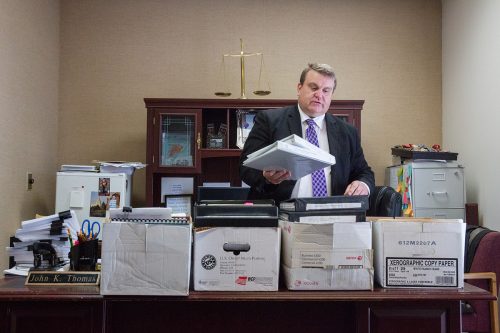 Attorney John Thomas shows four boxes of files from Christopher Tapp's trial and release hearing. Photo by Otto Kitsinger