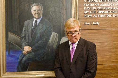 Craig Kelly (son of Dee J. Kelly) does his impression of his father's look with the Dee J. Kelly portrait that hangs in the lobby of the expanded Dee J. Kelly Alumni & Visitors Center. Photo by Mark Graham