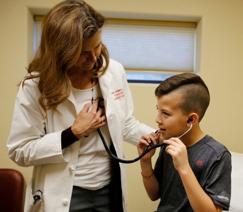 Dr. Wendy Bonnell lets Mauricio listen to her heart at Ruth's Place Clinic in Granbury, Texas. Mauricio is interested in being a physician. Photo by Ross Hailey
