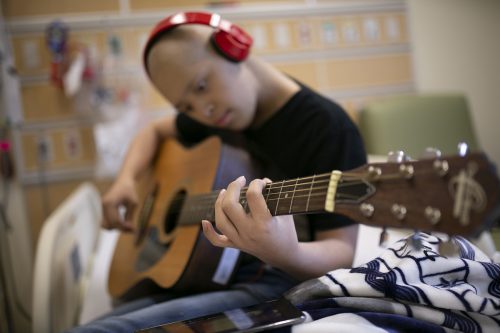 Uriel, 15, practices guitar in his room at Children's Medical Center Dallas. The guitar was donated to the hospital by Music Meets Medicine, a non-profit founded by Dr. J Mack Slaughter. Photo by Rodger Mallison