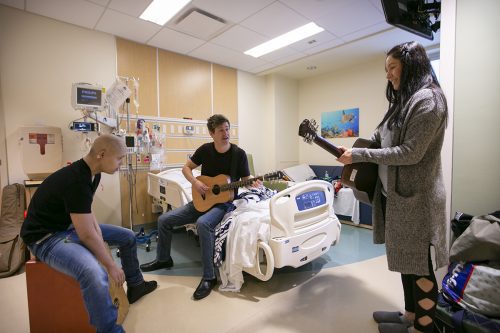 Dr. J Mack Slaughter (center) performs some tunes with Uriel, 15, and his mother Sara in Uriel's room at Children's Medical Center in Dallas. Photo by Rodger Mallison