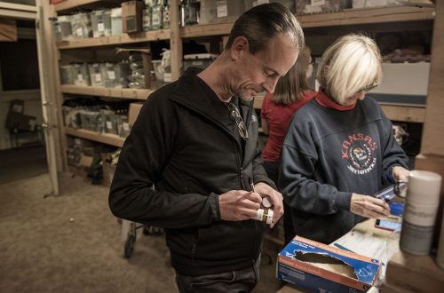 Dr. Brandon Pomeroy (left), one of the founders of Care Beyond the Boulevard, fills out a label on a prescription bottle as Kay Johnston (right), RN, counts pills. Photo by Shane Keyser