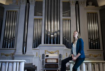 Elisa Bickers, principal organist and associate director of music ministry at Village Presbyterian Church, sits near the church's organ. Photo by Shane Keyser