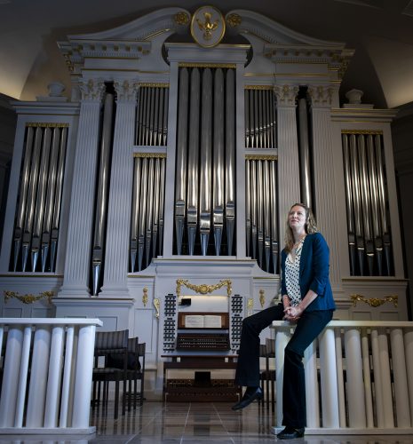 Elisa Bickers, principal organist and associate director of music ministry at Village Presbyterian Church, sits near the church's organ. Photo by Shane Keyser