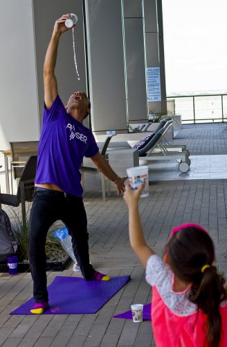 Poser Kids yoga leader Mateo Marquez shows how to pour a glass of water into his mouth while doing a yoga pose. He teaches the kids it is important to stay hydrated. Photo by Mark Graham