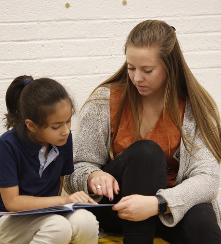 TCU student Amanda Smiley practices reading with Emily Guzman at Mary Louise Phillips Elementary school in Fort Worth. Photo by Ross Hailey