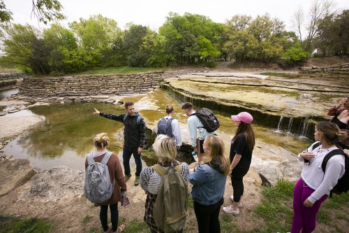 Adam Fung, associate professor of Art, explains the goals and safety rules as TCU art students use a variety of media to create art work at Airfield Falls Conservation Park. Photo by Rodger Mallison
