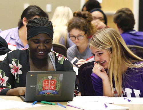 Young Womens Leadership Academy student Brooklynn Smith and TCU junior Abbie Mueller work on Brooklynn's essay as the Introduction to Women and Gender Studies class assisted Girls, Inc members. Photo by Ross Hailey