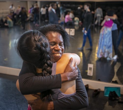 Godelieve Mukasarasi hugs a student after a November 2018 healing dance class. Photo by Rodger Mallison