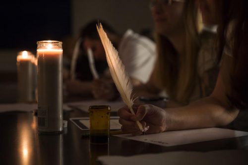 During an exercise called scriptorium by candlelight, Alex Hidalgo’s students copy Spanish manuscripts using iron gall ink and quills. Courtesy of Alex Hidalgo | Photo by Scott Murdock