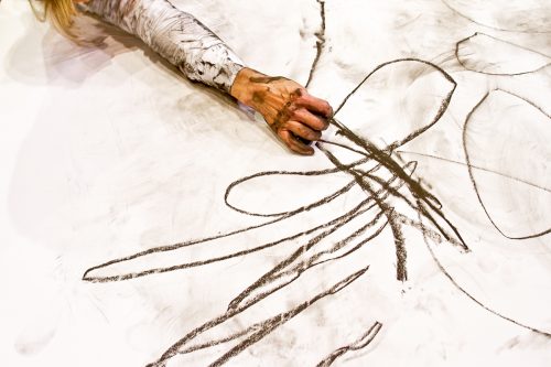 Detail from Nina Martin, associate professor of dance, performing her piece, Secondary Surface Rendered, which has been done with dancers of mixed ability. The work, done on white paper with charcoal, has been done with performers with cerebral palsy. This was done at the Erma Lowe Hall on the TCU Campus.