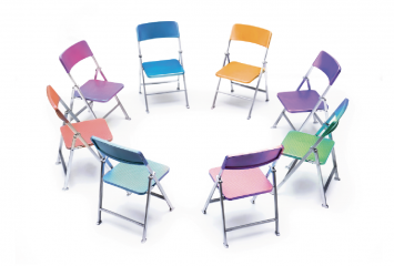 Different color folding chairs in a circle. Illustration by Getty Images | CORDELIA MOLLOY