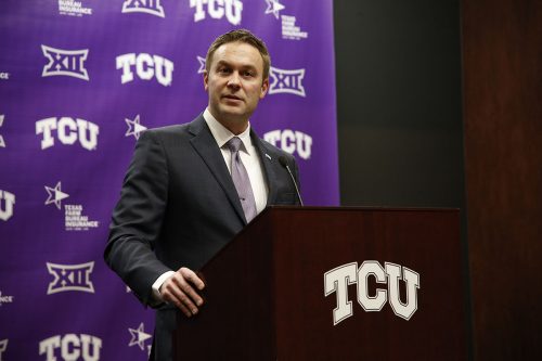 Jeremiah Donati stands at a TCU podium in front of a TCU step and repeat backdrop.