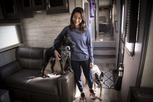 Ive Mota Avila gets ready to walk her dog Blue, left, and Winter, before studying in her RV home. 