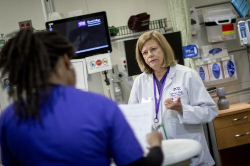 Melissa Sherrod, Professor of nursing for the TCU Harris College of Nursing and Health Sciences, briefs a student on her simulated patients in a nursing simulation lab in the Annie Richardson Bass Building. Photo by Rodger Mallison, October 31, 2019