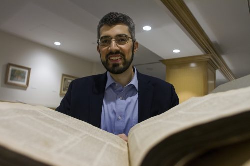 Samuel Ross, assisitant professor of religion, is researching the biblical turn on Qua'anic commentaries, with one of the bibles in Special Collections at the Mary Couts Burnett Library.