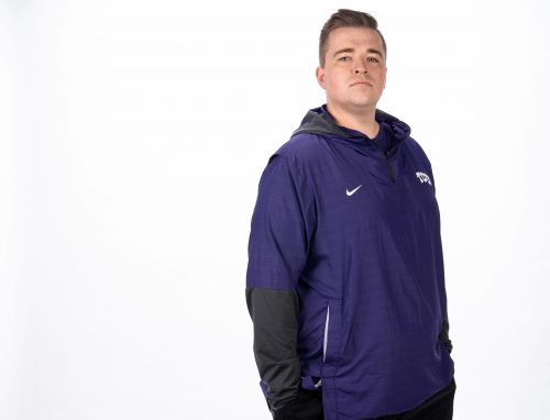 Michael Wood stands in front of a white background. He is wearing TCU athletic wear. His hands are in his pockets.