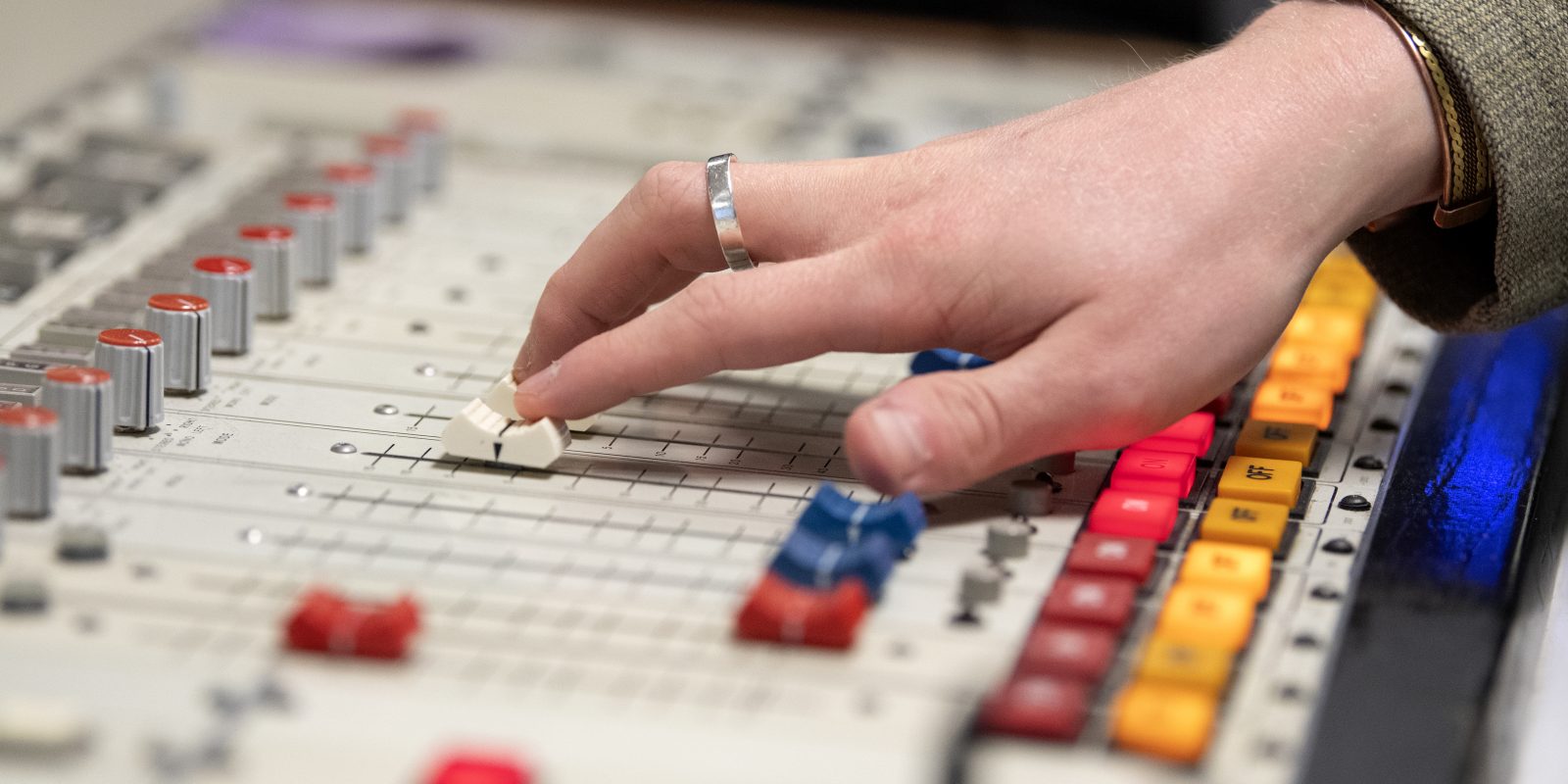 A hand slides a key on a radio control board.