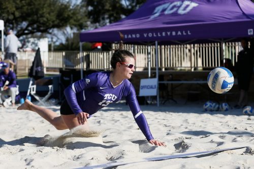 Daniela Alvarez lunges for a volleyball in a sand court