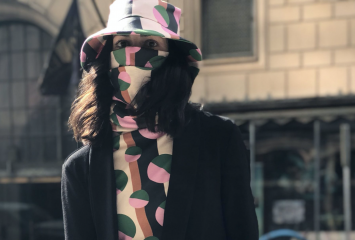 A patterned turtleneck shirt that extends to a face covering with a matching hat.