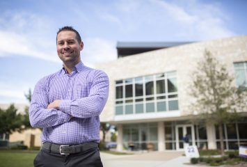 Dr. Zachary Hall, Assistant Professor of Marketing, poses outside the Steve and Sarah Smith Entrepreneurs Hall at the Neely School of Business at TCU.