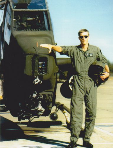 Todd Weiler standing next to a military helicopter.