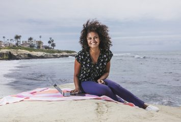 Sneha Popley sits on the beach in California.