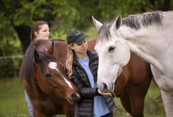 TCU sophomore Tyler Morris, 19, left, and senior Hannah Divic, 23, right, interact with the horses during a workshop on Friday, April 16, 2021. In the fall 2020 semester, the TCU Counseling & Mental Health Center partnered with certified equine therapist Lesli Figueiredo to provide equine groups specific for TCU students. Horses shown are Joe (center) and Kairos (right, foreground). Photo by Joyce Marshall