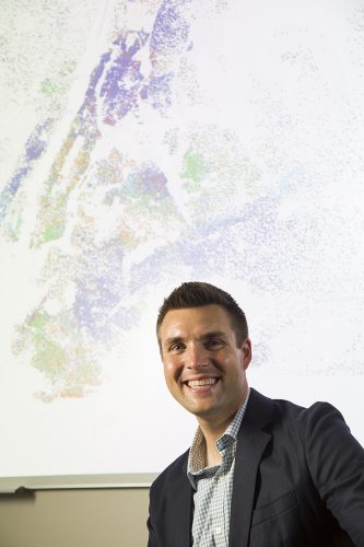 A portrait photo of Kyle Walker in front of a colorful map.