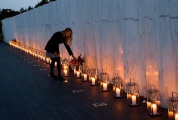 SHANKSVILLE, PA - SEPTEMBER 10: A woman adjusts an bouquet of flowers at Flight 93 National MemorialÕs annual Luminaria on the eve of 16th Anniversary ceremony of the September 11th terrorist attacks, September 10, 2017 in Shanksville, PA. United Airlines Flight 93 crashed into a field outside Shanksville, PA with 40 passengers and 4 hijackers aboard on September 11, 2001. (Photo by Jeff Swensen/Getty Images)