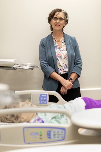 Wendy Macias stands in a simulation hospital room