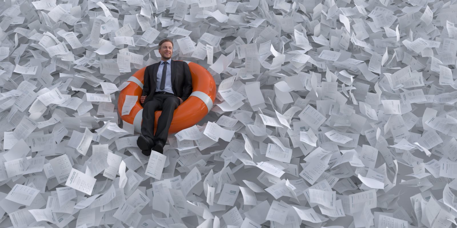 A man wearing a suit sits in a life raft in a sea of paper.