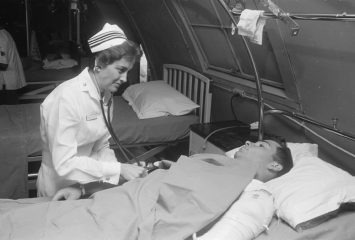 Da Nang, South Vietnam...United States Navy nurse Lieutenant Commander Joan Brouilette checks the condition of Pfc. Charles Smith as she makes her daily rounds of the intensive care ward at the United States Naval Support Activity Hospital. January 6, 1968