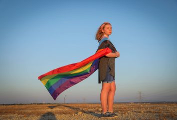 Maggie Peterson photographed with a pride flag, October 22, 2021. Photo by Amy Peterson