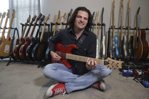 Feb. 27, 2024. In his home studio in Fort Worth, Texas, Grammy winning guitarist and composer Mark Lettieri '05 plays a red version of the “Fiore” model Paul Reed Smith guitar he designed for the company. (Photo by Ralph Lauer)