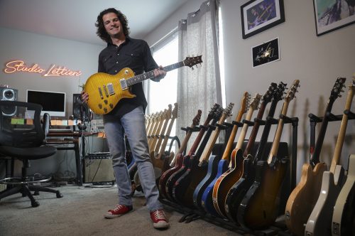 Feb. 27, 2024. In his home studio in Fort Worth, Texas, Grammy winning guitarist and composer Mark Lettieri '05 holds one of the guitars from his extensive collection. (Photo by Ralph Lauer)