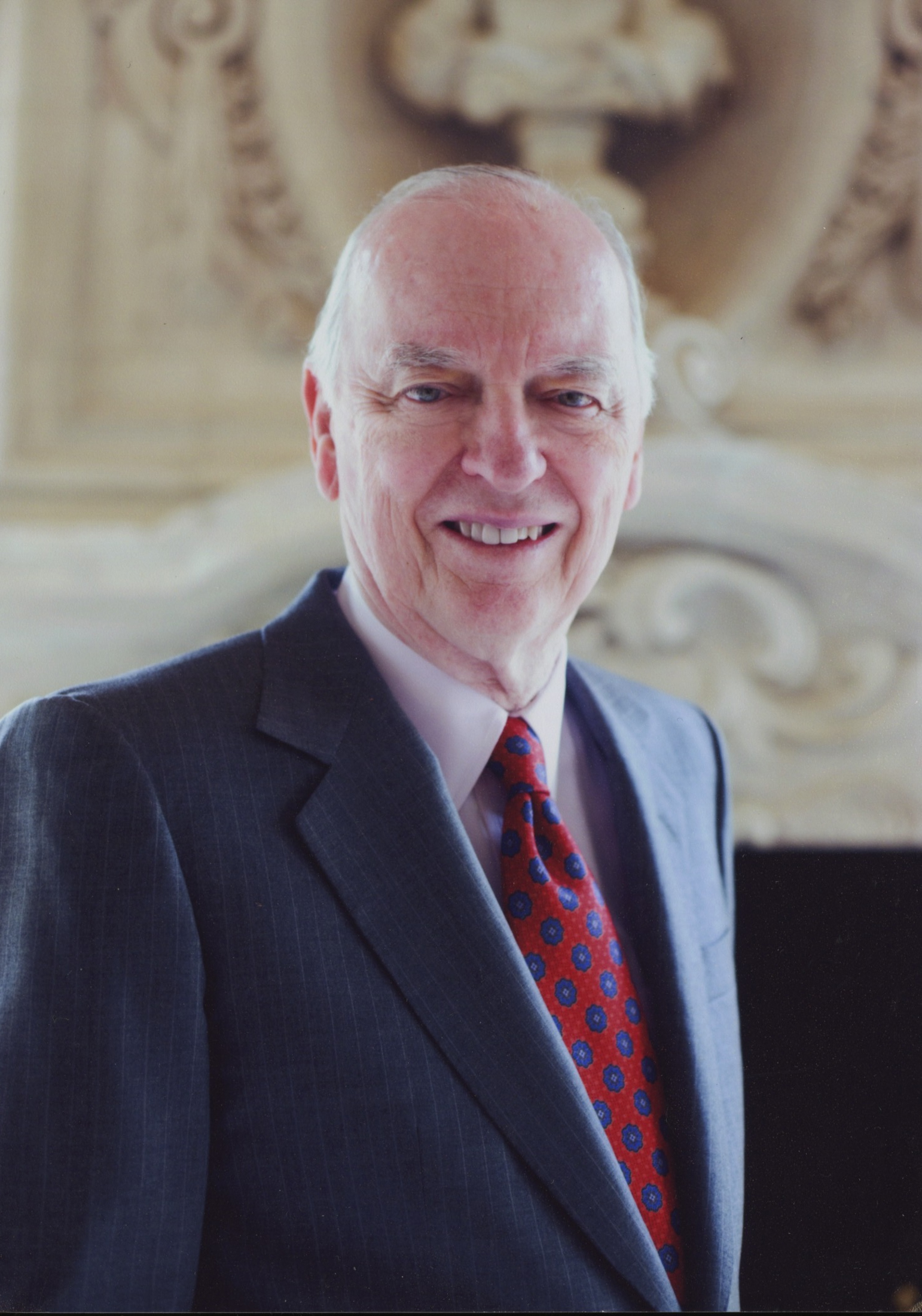 A portrait photograph of Ben J. Fortson. Mr. Fortson is dressed in a red tie, a dress shirt and a navy blue blazer.