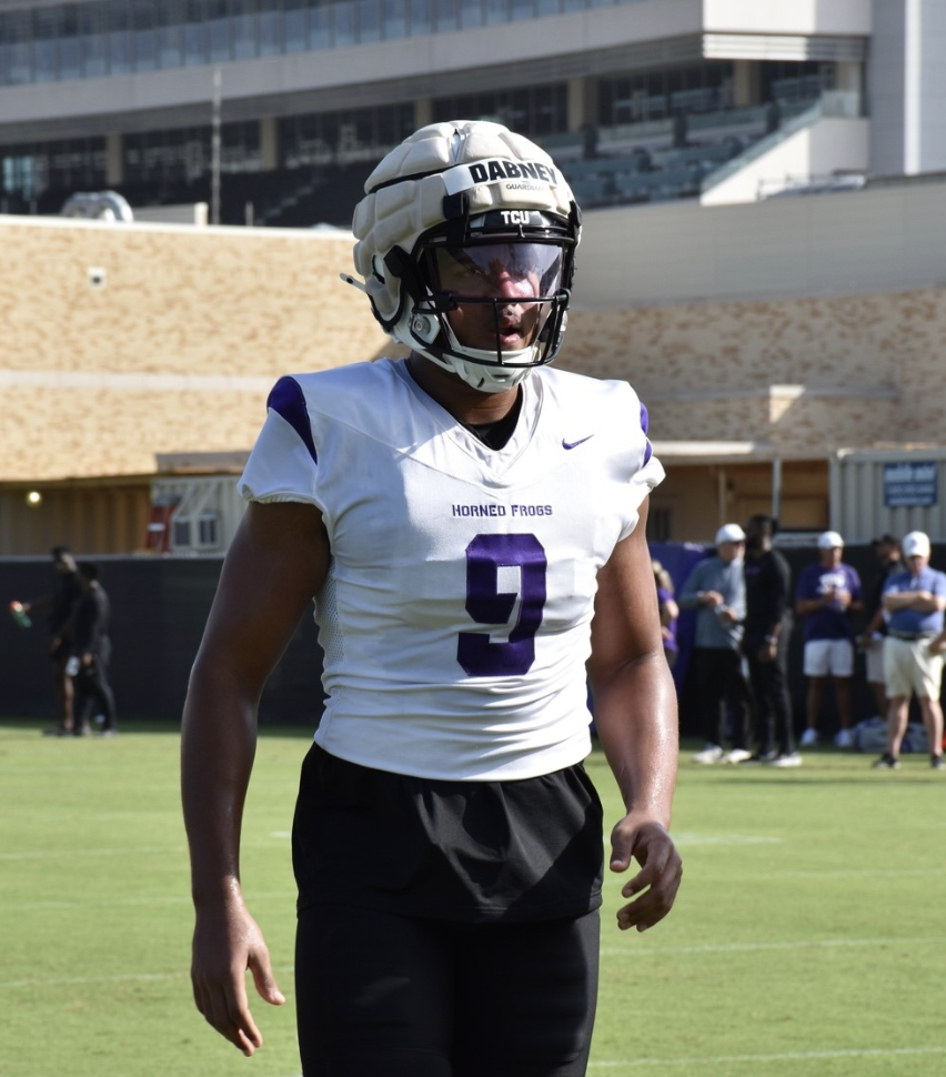 Drake Dabney at TCU fall camp. The tight end is wearing a helmet with a head protector and a sticker across the front reading "Dabney." He's wearing a white practice jersey with the number 9 embroidered in purple across the front.