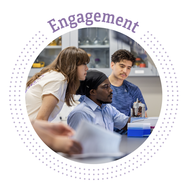 Photograph of three students congregated together in what looks like a school laboratory. The students are each gazing forward in the same direction.