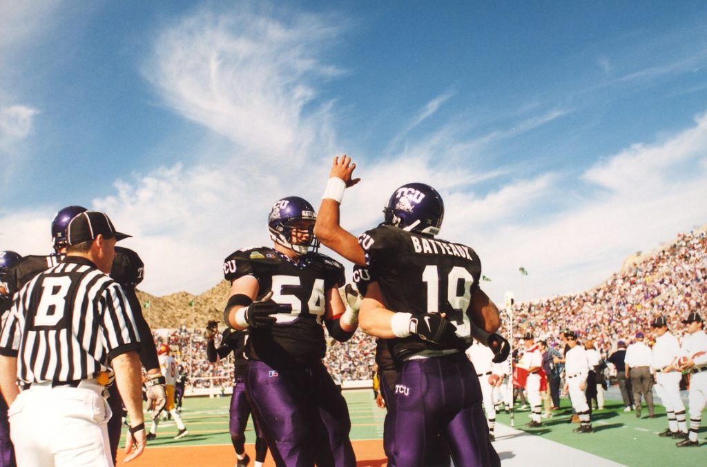 TCU quarterback Patrick Batteaux '00 celebrates in a back corner of the end zone with a group of Horned Frogs teammates during a 28-19 Sun Bowl win over the USC Trojans.